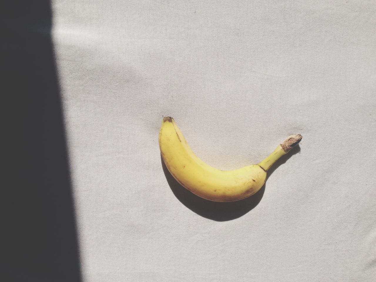 yellow, food and drink, one animal, food, animal themes, fruit, animals in the wild, close-up, wildlife, healthy eating, indoors, high angle view, copy space, still life, freshness, banana, single object, table, no people, bird