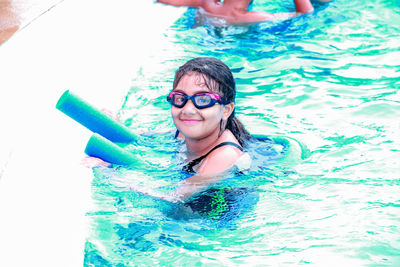 Portrait of smiling woman swimming in pool