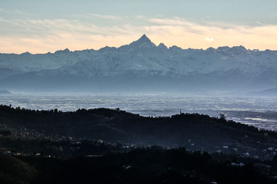 Scenic view of snowcapped mountains against sky during sunset