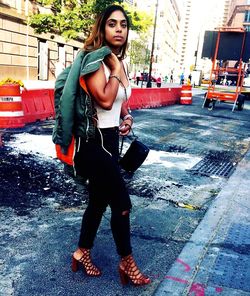 Full length portrait of woman standing in city