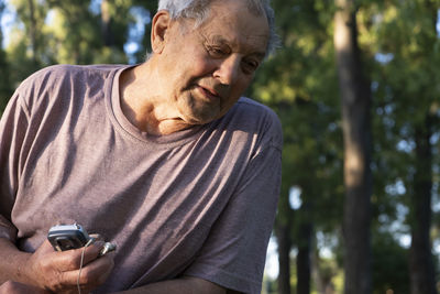 Portrait of senior adult man holding his radio