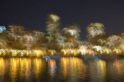 Illuminated firework display over water at night