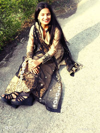 Portrait of a smiling young woman sitting outdoors