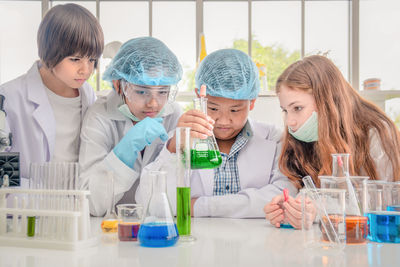 Students examining chemical in school laboratory