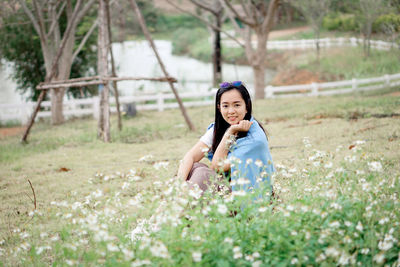 Portrait of young woman standing on field