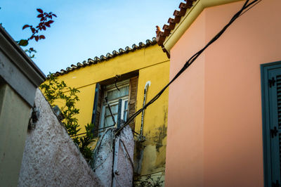 Low angle view of cables on building against clear sky