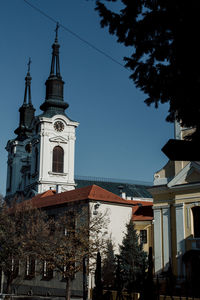Low angle view of trees and buildings against sky