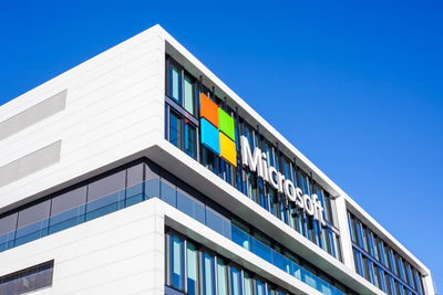 Low angle view of modern building against clear blue sky