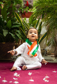 Cute toddler holding indian tricolor flag in traditional cloth with innocent facial expression