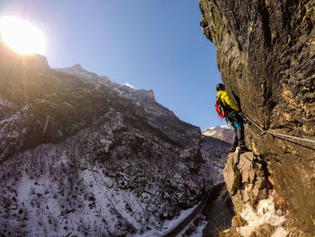Full length of man climbing on mountain during winter