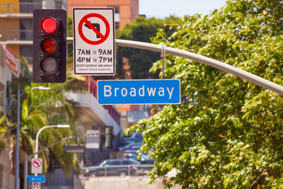 Road sign by trees in city