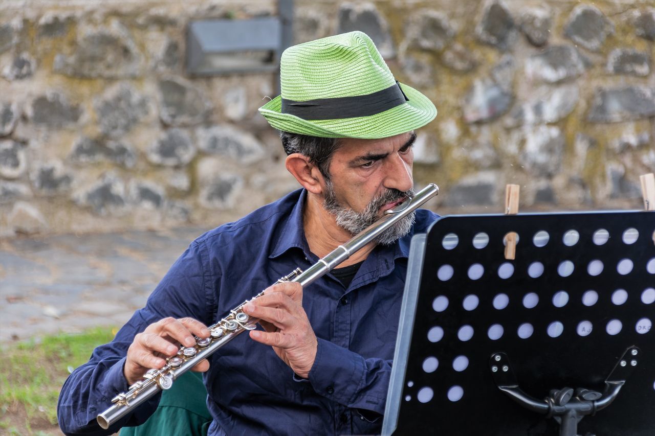 music, musical instrument, hat, musician, adult, one person, playing, clothing, real people, front view, mature men, musical equipment, arts culture and entertainment, string instrument, mature adult, holding, men, day, artist, skill