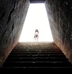 Low angle view of woman standing on staircase