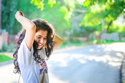 Happy young woman against tree