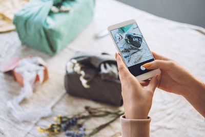 Cropped hand of woman using mobile phone