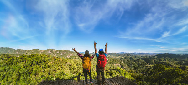 Rear view of woman standing on mountain against sky