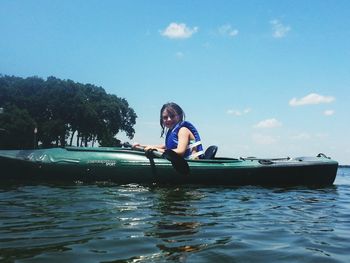 Portrait of cute smiling girl kayaking in lake