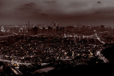 Aerial view of illuminated cityscape against sky at night