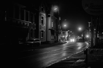 Street amidst illuminated buildings in city at night