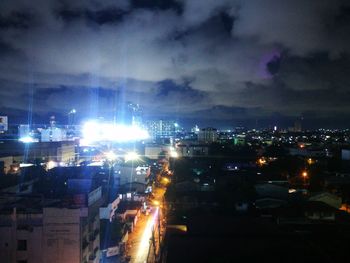 Illuminated cityscape against sky at night