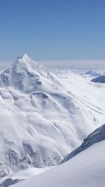 Scenic view of snowcapped mountains against clear blue sky