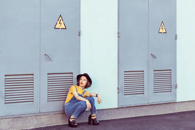 Portrait of man sitting against wall