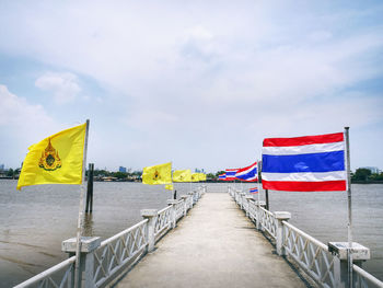 Elevated walkway over the river decorated with national flags of thailand