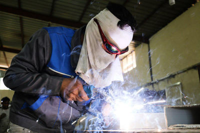 Welder welding in workshop