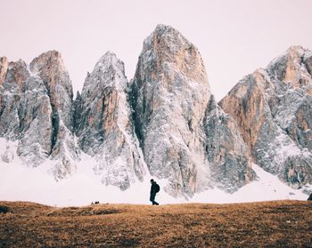 Man standing on rocky mountain against clear sky