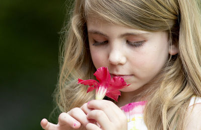 Close-up portrait of woman holding red flower