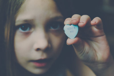 Close-up portrait of girl holding candy saying "you and me"