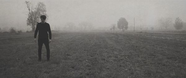 Rear view of silhouette man on field against sky