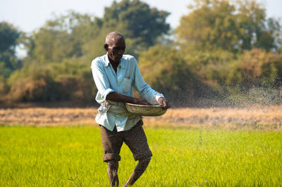 Farmer working while standing on field