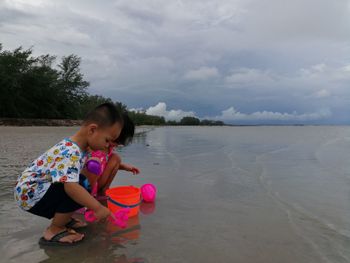 Side view of girl on beach against sky