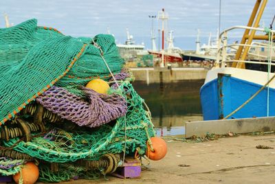 Fishing net on concrete with boat in background