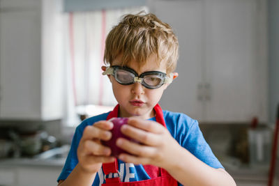 Close-up of boy wearing swimming goggles at home