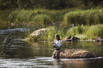 Woman fishing in lake