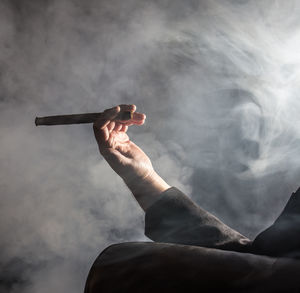 Close-up of man holding cigar