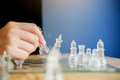 Cropped hand of person playing chess at home