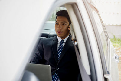 Businessman talking on phone while traveling in car