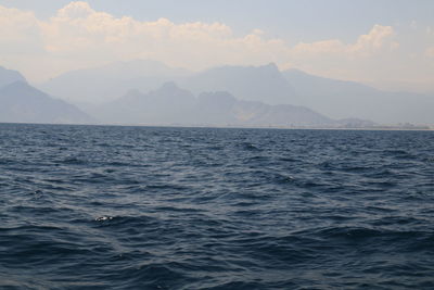 Scenic view of sea and mountains against sky