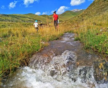 Man riding horse on mountain against sky