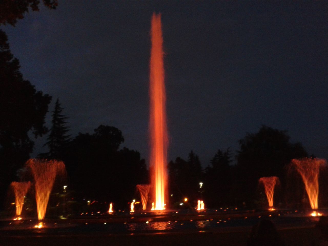 night, illuminated, tree, silhouette, sky, copy space, motion, glowing, clear sky, fountain, burning, dark, outdoors, flame, nature, fire - natural phenomenon, light - natural phenomenon, long exposure, no people, incidental people