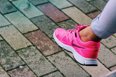 Low section of woman standing on footpath