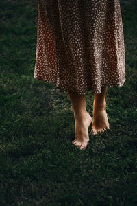 Low section of woman standing on field