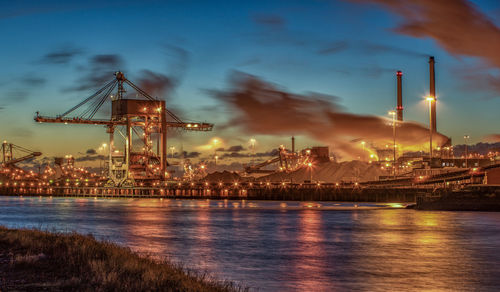 City at waterfront against cloudy sky