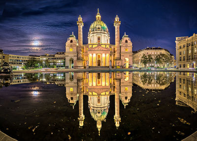 Reflection of illuminated building in water at night