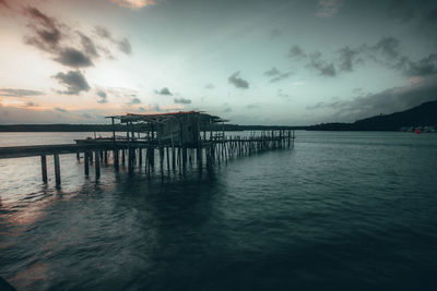 Pier over sea against sky at sunset