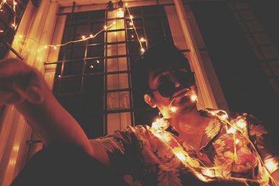 Portrait of woman holding illuminated lighting equipment