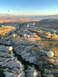 Hot air balloons flying over landscape against sky